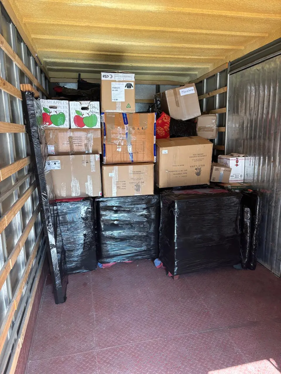 Trabajadores descargando cajas de cartón desde camión de mudanza