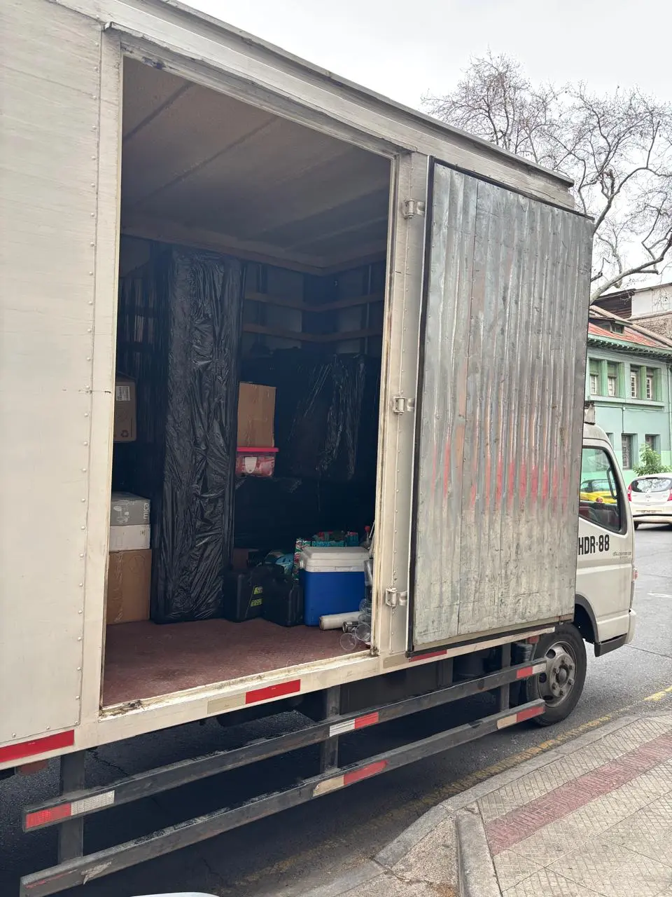 Dos trabajadores de mudanza cargando un colchón blanco